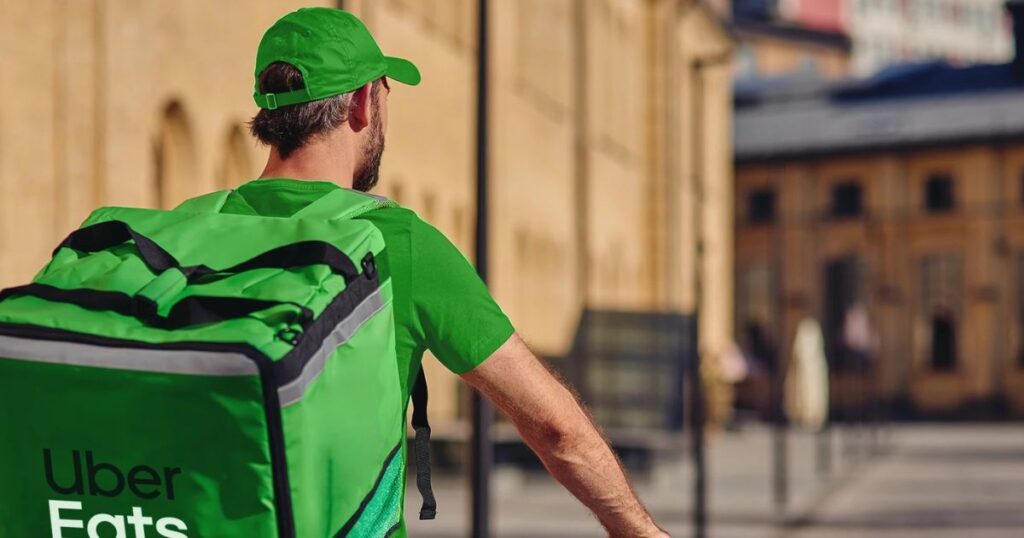 Kurier Uber Eats z torbą dostawczą w mieście